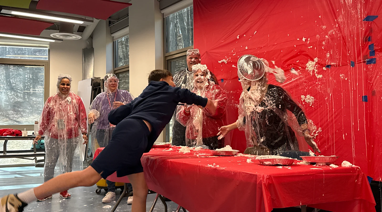 student throws a pie at a staff member for Pi Day
